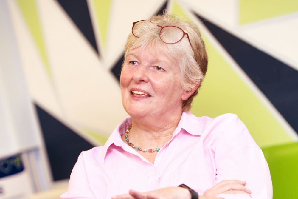 Dr Louise May sitting, smiling in relaxed way