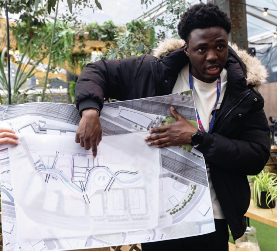 Picture of young black male showing planes for new road layout