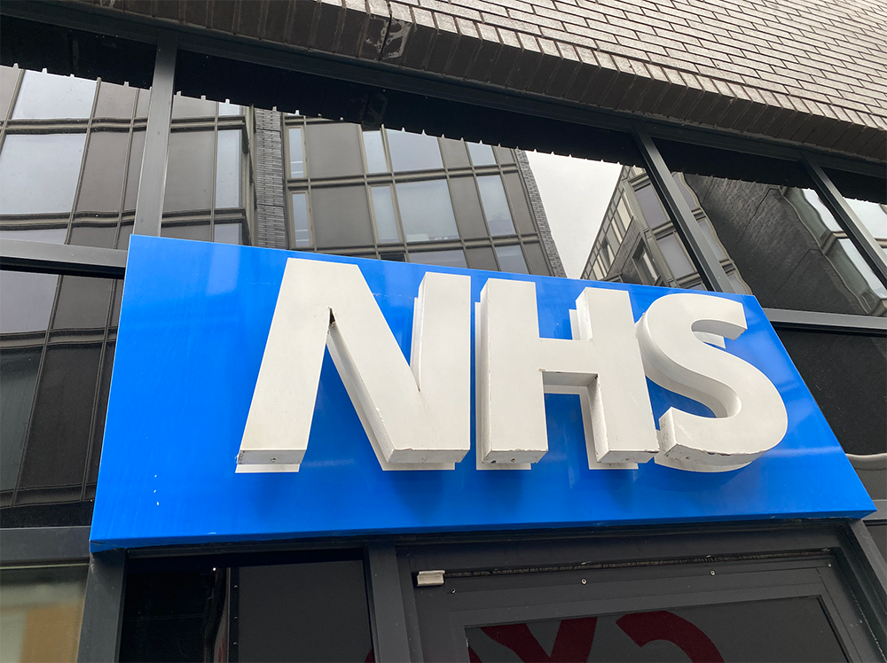 NHS logo on side of building - white text on blue background