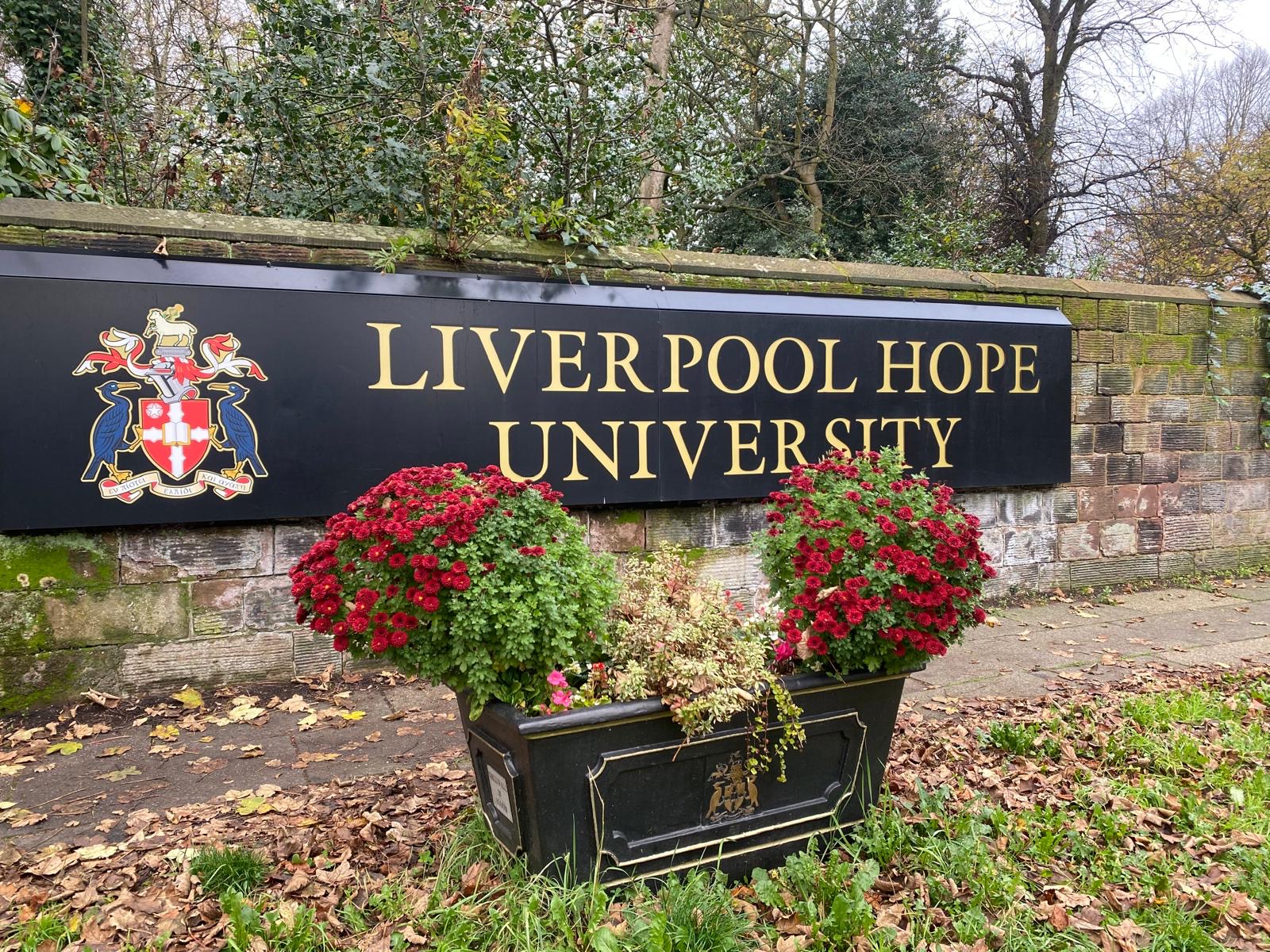 Image of sign for entrance to Liverpool Hope University with flower bed in front of it