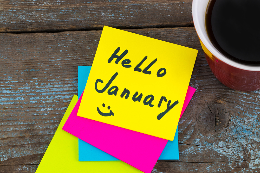 Fluorescent post it notes with message hello January on wooden table top