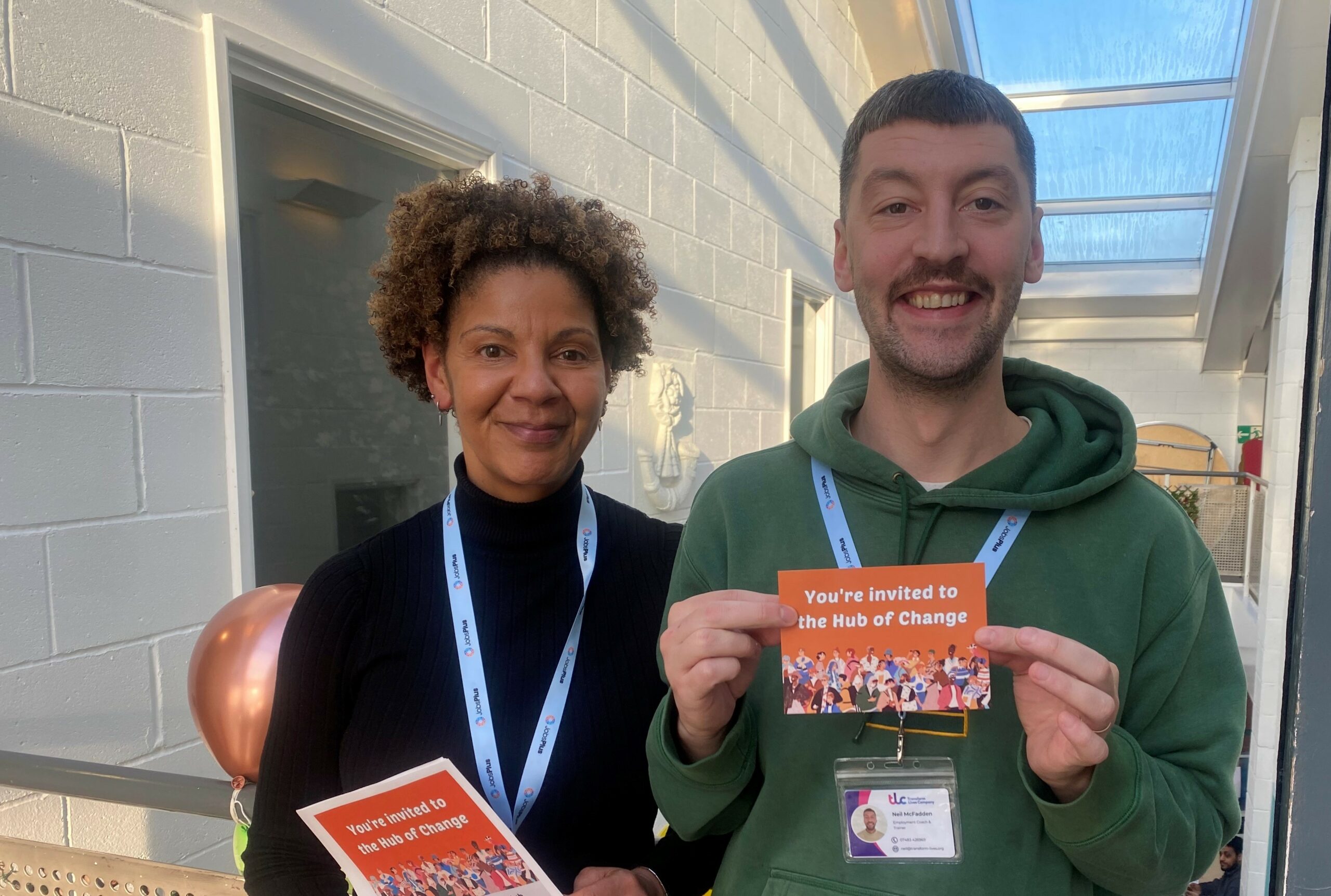 Male and female job centre plus staff holding flyers promoting the service